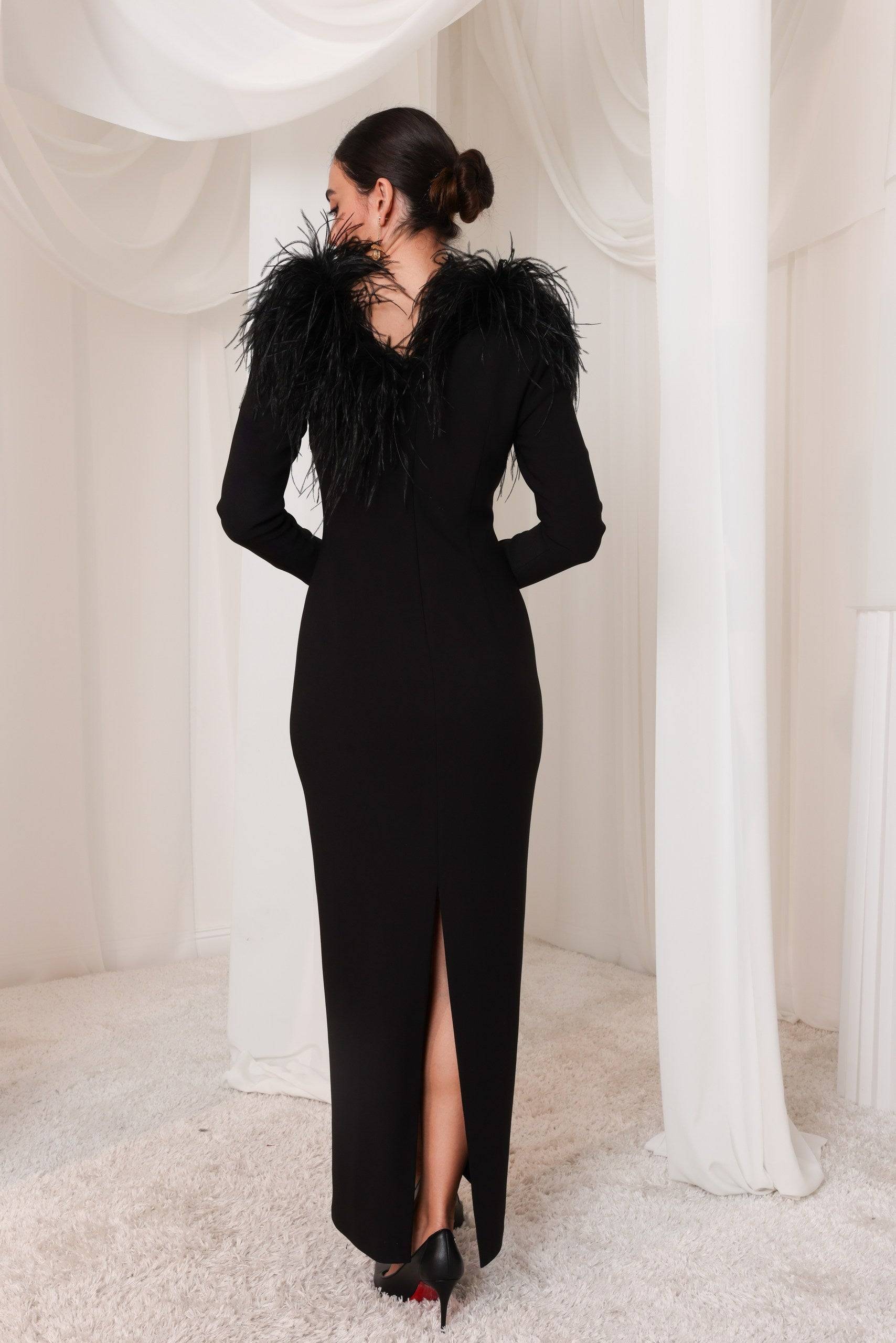 Back view of Al-Layl Al-Aswad black gown with feather trim, showcasing a sophisticated slit detail. Ideal for luxury evening occasions.