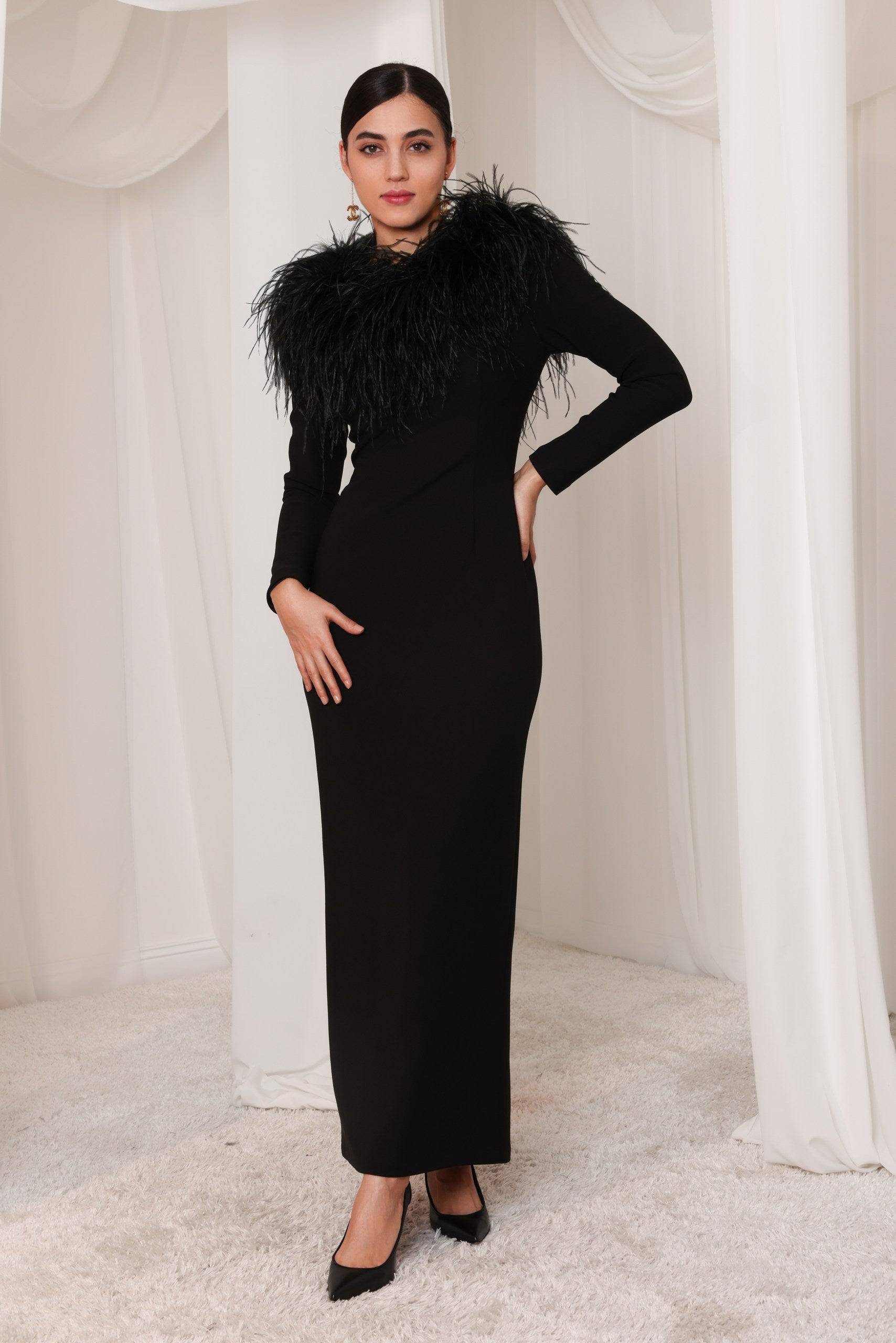 Al-Layl Al-Aswad black gown with feather trim, featuring a sleek silhouette and long sleeves. Perfect for elegant evening wear and formal events.